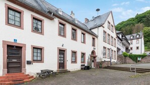 A traditional European building with multiple windows, a central entrance, and a paved courtyard. - 2 bedroom stunning apartment in Malberg (Malberg)