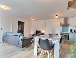 Un appartement moderne comprenant un coin repas, un canapé, une cuisine et un salon.