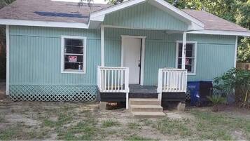 A single-story house with a front porch, a small front yard, and a mailbox.
