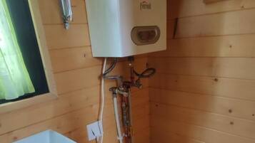 Een kleine badkamer met een wit toilet, een wastafel en een wandradiator.