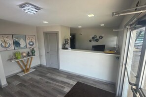 A reception area with a desk, a door, and a wall with decorative items. - Express Inn New Albany I 22 (New Albany)