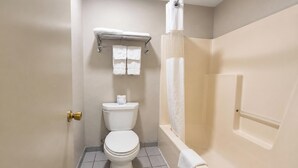 Een badkamer met toilet, douche en handdoekrek.