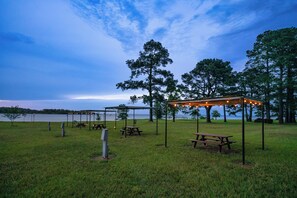 Un parco con tavoli da picnic e un gazebo decorato con luci.