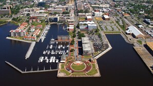 An aerial view of a marina with boats docked, surrounded by buildings and a central roundabout. - Relax at our Gulf Beach Retreat (Pensacola)