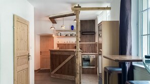 Una cucina con mobili in legno, un'isola centrale, illuminazione a sospensione e una finestra con tende.