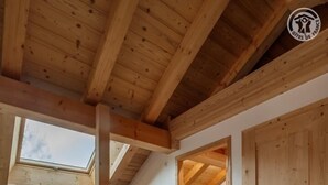 An interior with a wooden ceiling, a skylight, and a tiled floor. - Chalet Lamartine - Valloire (VALLOIRE)