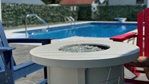 A poolside area with a gas tank, a pool, and a red chair. - conveniently located home is perfect for families and friends , near Hershey ! (Palmyra)