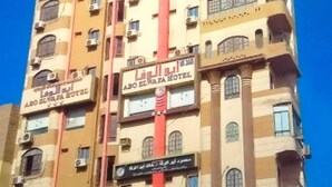 A multi-story hotel with balconies and air conditioning units.