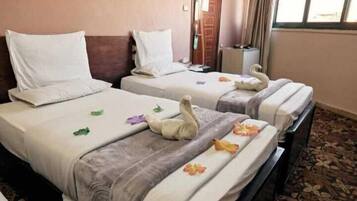 Due letti d'albergo con asciugamani e cuscini decorati a forma di cigno.
