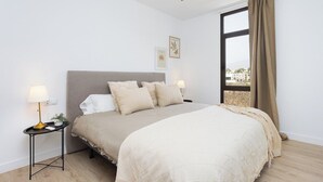 A bedroom with a bed, bedside tables, a ceiling fan, and a window with curtains. - Home2Book Stylish Apt Terrace Las Américas (Playa de la Américas)