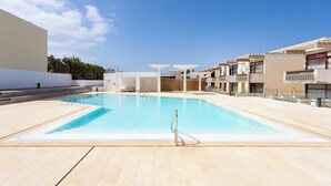 A swimming pool with a clear blue water surface, surrounded by a tiled deck area. - Home2Book Stylish Apt Terrace Las Américas (Playa de la Américas)