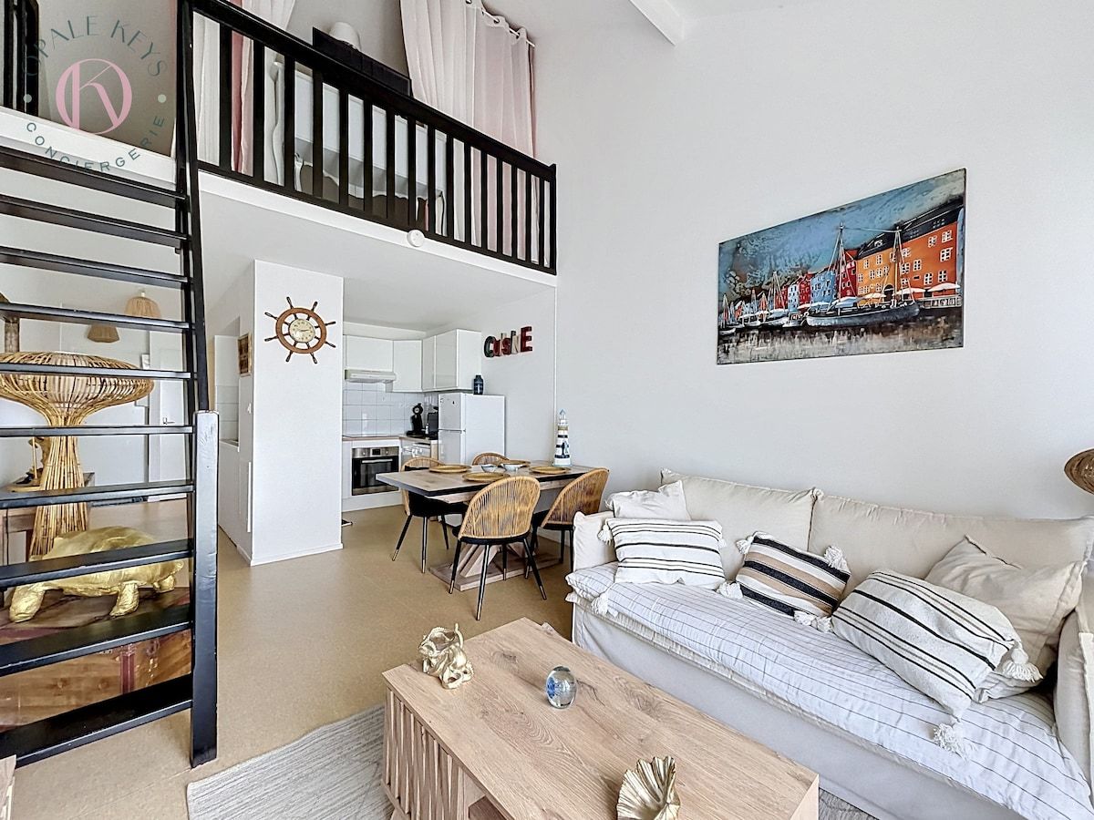 Un appartement moderne comprenant un coin repas, un canapé et un tableau au mur.