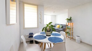 A modern living space with a dining area, a sofa, a plant, and a shoe rack. - Apartment with parking in Tlaquepaque Pueblo Mágico (Guadalajara)