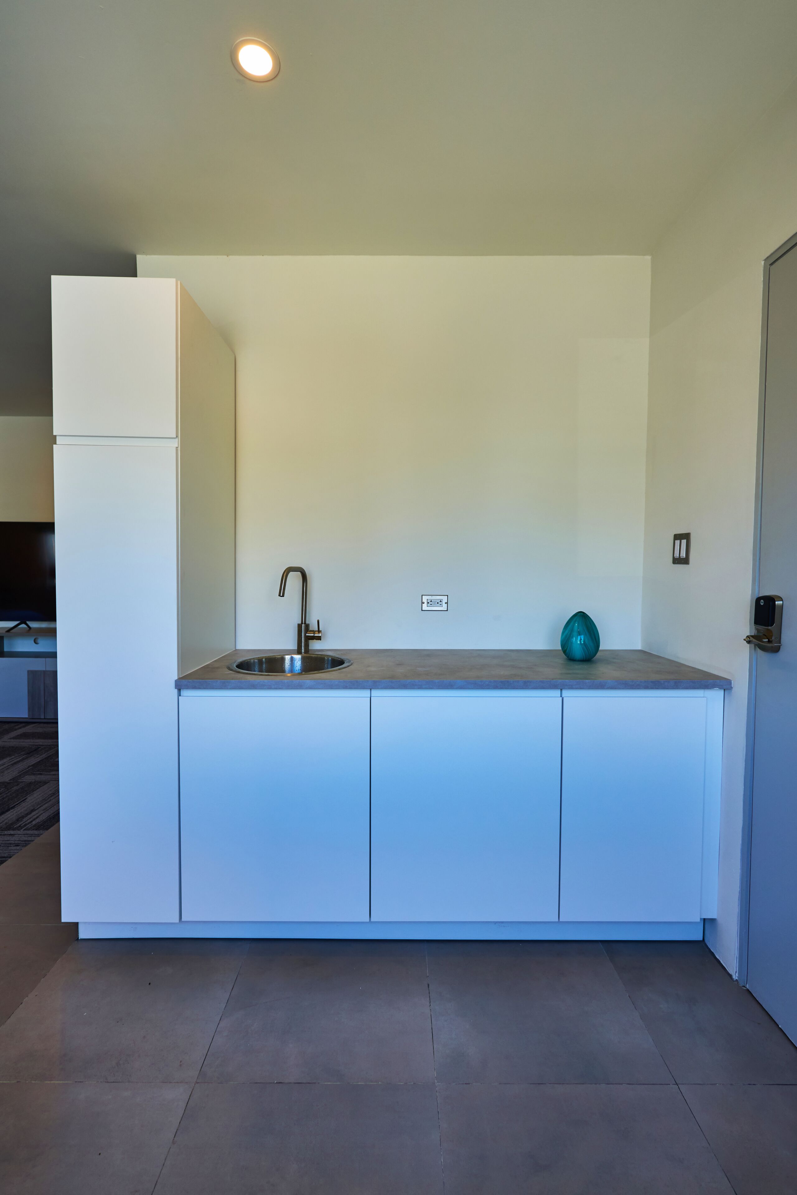 Eine moderne Küche mit Spüle, einem blaustreifen Säckchen und einem Kühlschrank.
