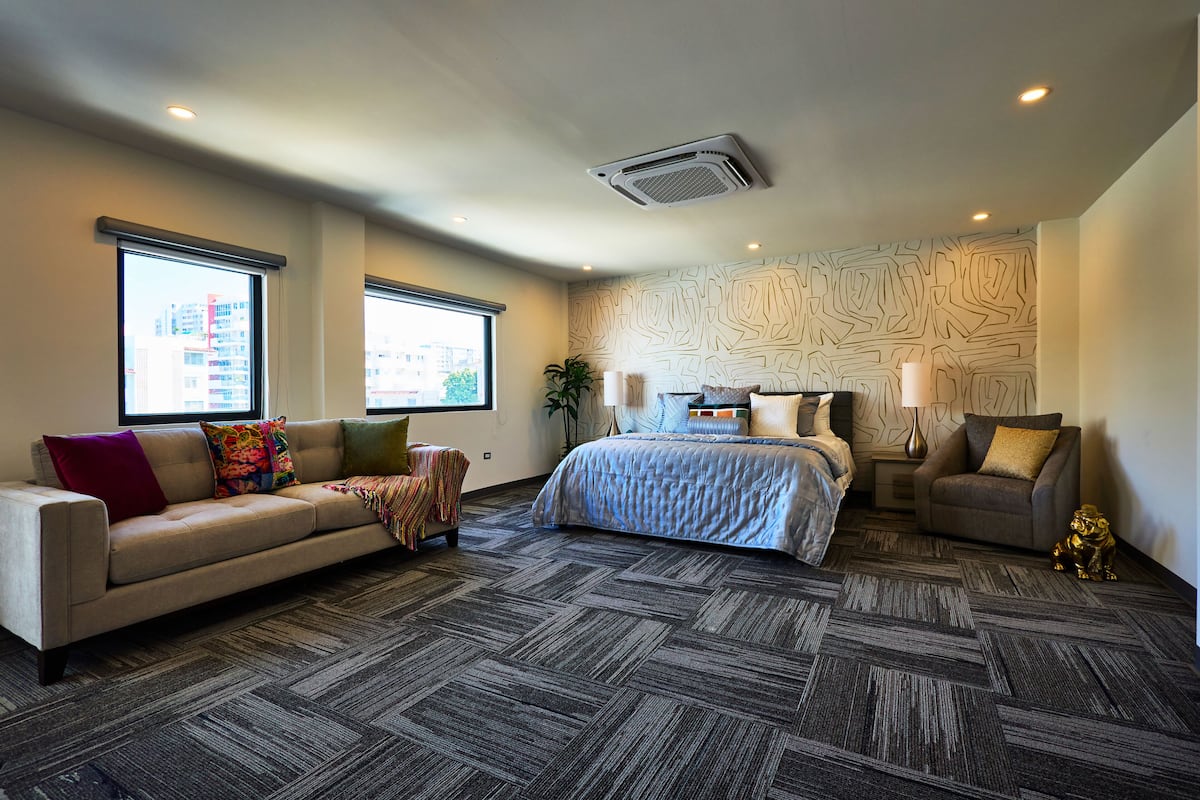 Een hotelkamer met een groot bed, een slaapbank en een bureau.