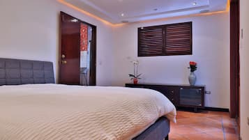Un dormitorio con cama, cómoda, ventana con persianas y puerta.