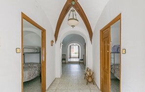 A narrow hallway with bunk beds on either side, leading to a bright room with a view. - 3 bedroom awesome home in Villanueva del Rey (Villanueva del Rey)
