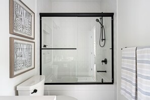 Une salle de bain moderne avec une douche à parois de verre, des toilettes et un lavabo.