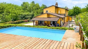 A yellow house with a swimming pool and wooden deck. - Cozy apartment in Santa Maria a Monte (Santa Maria a Monte)