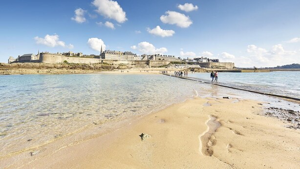 A coastal beach with clear waters, a pier, and historic buildings in the background. - Le Rocher - Trelivan (TRELIVAN)