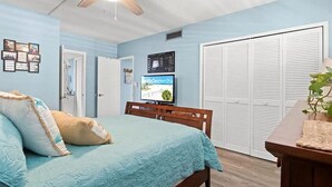A bedroom with a bed, a ceiling fan, a TV, and a wardrobe. - Golf/Water View Condo
 (Sarasota)