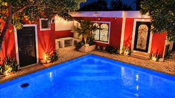 A swimming pool with a red and white building in the background.
