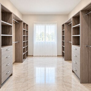 Ein Zimmer mit großem Fenster, Holzregalen und Fliesenboden.