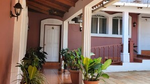 A covered outdoor area with a tiled floor, potted plants, and a wooden ceiling. - Hotel Mar y Mar (San Marcos)
