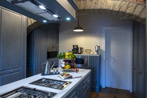 A modern kitchen with a central island, stainless steel appliances, and a hanging pendant light. - MyExclusiveItaly - Villa Chianti with infinity pool and vineyard view (Greve in Chianti)