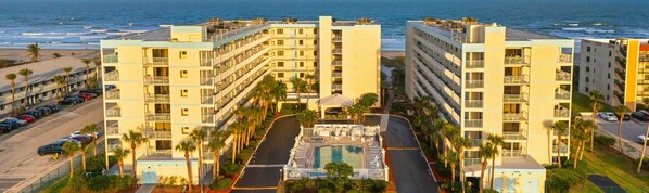 Un hôtel doté d’une piscine, offrant une vue sur la plage et situé à seulement une minute à pied de la plage.