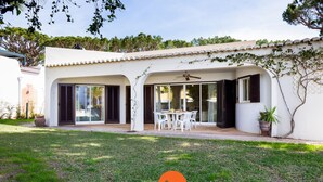 Ein modernes Haus mit Terrasse, Gartenmöbeln und einem Garten.
