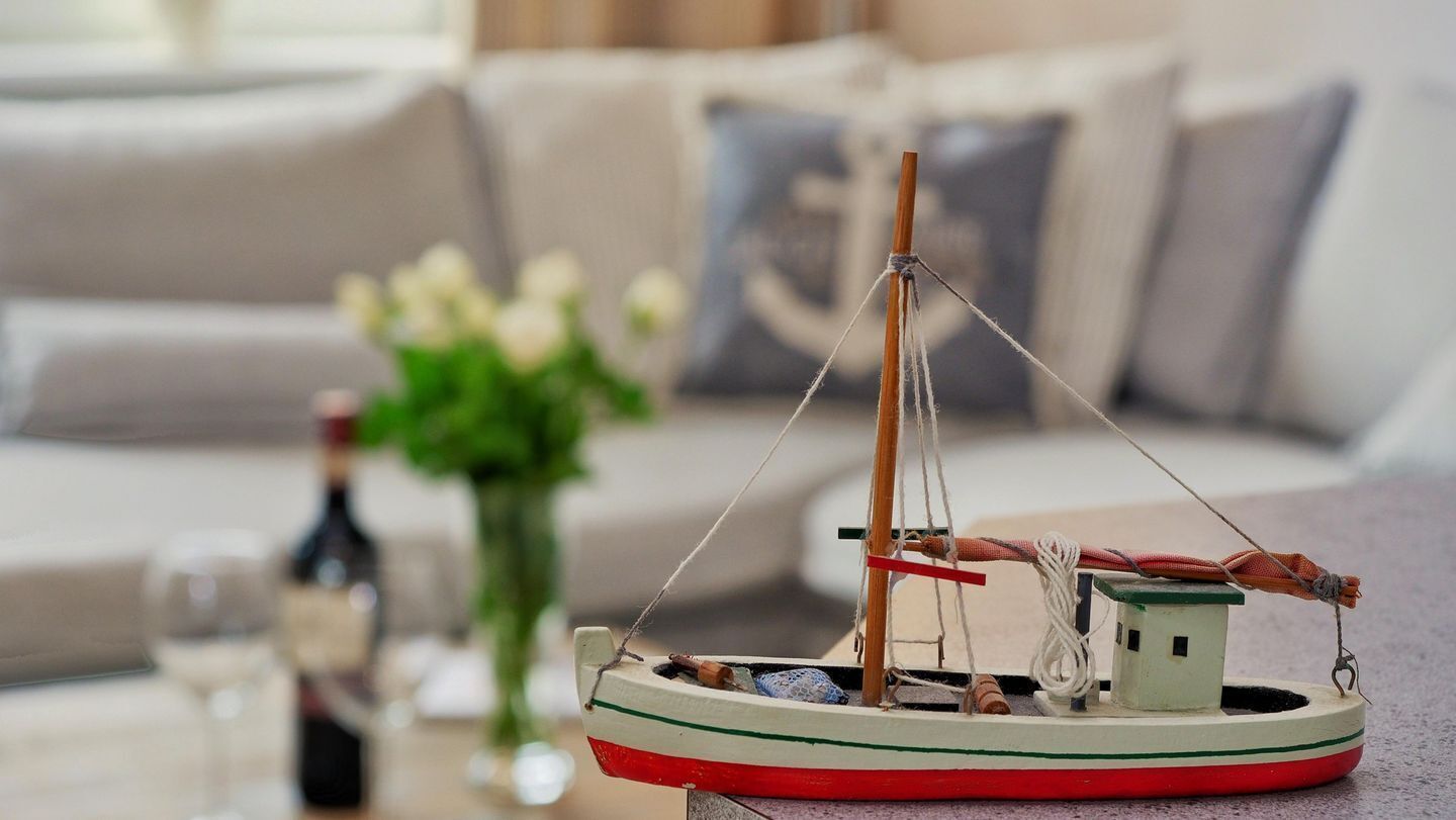 A model boat on a table with a blurred background of a living room.