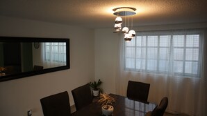 A dining area with a table, chairs, a potted plant, and a ceiling light fixture. - ¡ A 100 MTS DEL Reloj Monumental Aqui SI VAS A Estar EN EL Centro DE LA Ciudad ! (Pachuca de Soto)