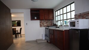 A kitchen with wooden cabinets, a stove, a microwave, and a refrigerator. - ¡ A 100 MTS DEL Reloj Monumental Aqui SI VAS A Estar EN EL Centro DE LA Ciudad ! (Pachuca de Soto)