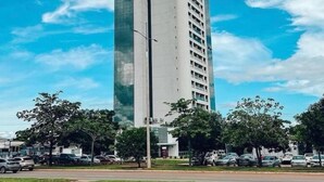 Un edifici alt i modern amb façana de vidre i un rètol que diu "VIVE DE LOS TIJOS".