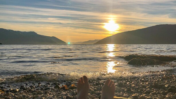 A sunset over a body of water with rocky shores and mountains in the background. - 3 bedroom beautiful home in Vik i sogn (Vik i sogn)