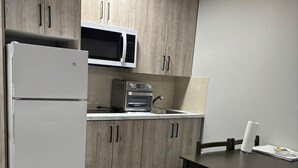 A compact kitchen with a refrigerator, microwave, toaster, and a sink. - Bethel Hotel Elk Point (Elk Point)