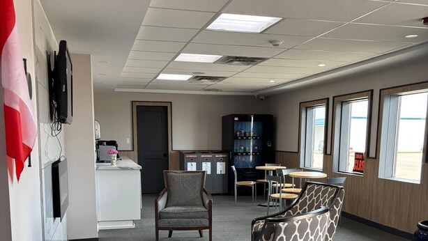 A spacious office with a modern design, featuring a reception area, several seating arrangements, and large windows providing natural light. - Bethel Hotel Elk Point (Elk Point)