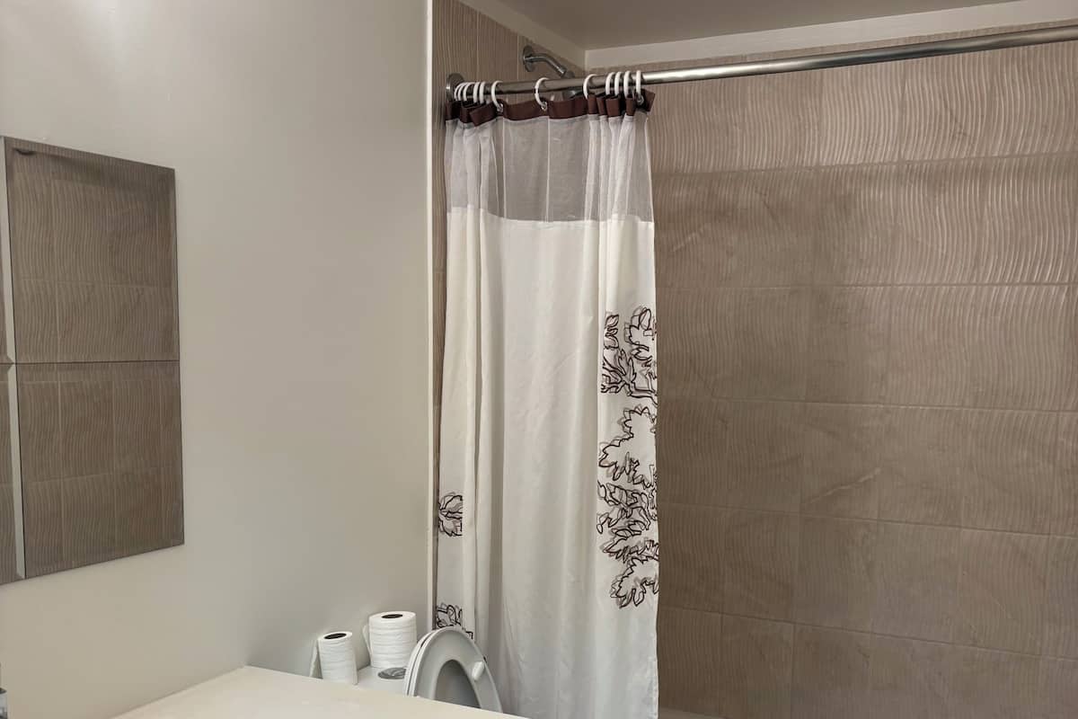 Et badeværelse med toilet, vask og badekar.