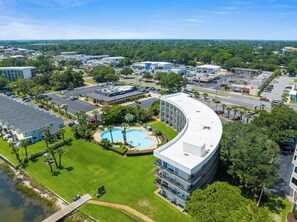 Un hôtel moderne doté d’une piscine, entouré d’un parking et de verdure.