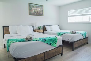 A hotel room with two beds, a nightstand, a lamp, and a painting on the wall. - Cozy Home with  PoolJacuzzi-Central Location (Las Vegas)