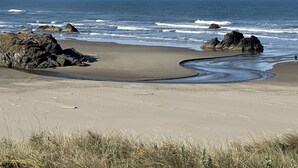 Een strand met rotsachtige uitstulpingen en een zandkust.