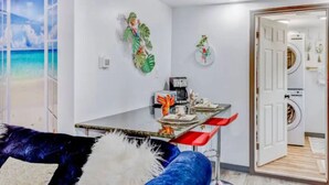 A modern kitchen with a dining area, a view of the beach through a large window, and a laundry room visible through an open door. - Cozy stylish home near Hershey park and so many (Campbelltown)