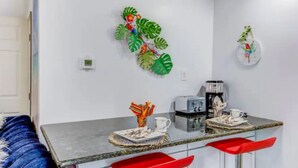 A modern kitchen with a marble countertop, red bar stools, and decorative wall art. - Cozy stylish home near Hershey park and so many (Campbelltown)