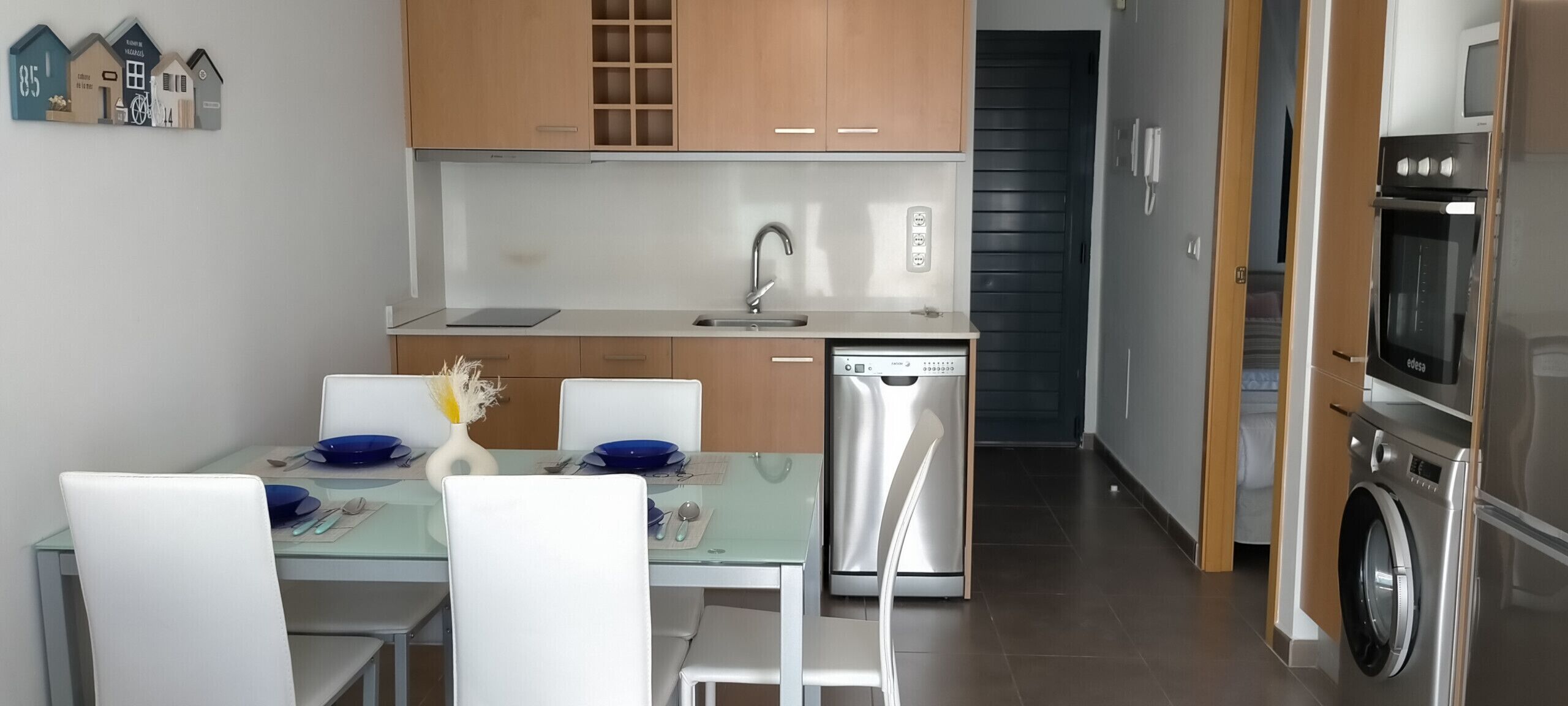 Eine moderne Küche mit Holzschränken, einem Geschirrspüler und einem eingebauten Backofen.