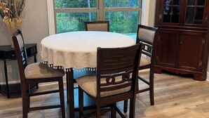 A dining area with a round table, four chairs, and a cabinet. - Heritage Cove  Hide Away 
 charming 3 bed
New Albany only 35 min from Oxford. (New Albany)