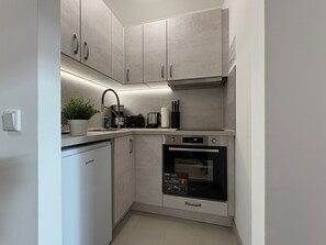 Køleskab, brødrister, køkkentøj/tallerkener/redskaber, spisebord