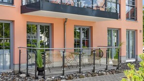 A modern building with a balcony, glass doors, and outdoor seating. - Pet friendly apartment in Putbus with sauna (Putbus)