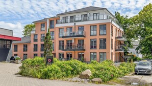 A multi-story residential building with balconies, a paved driveway, and a sign indicating private property. - Pet friendly apartment in Putbus with sauna (Putbus)