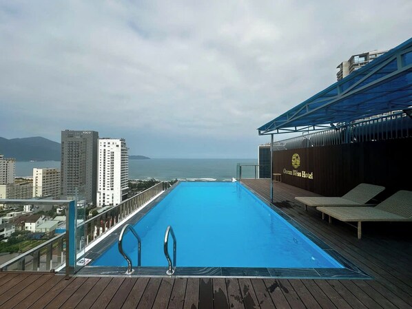 Una piscina a sfioro sul tetto con vista sull'oceano e sulla città.